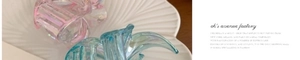 Close-up of iridescent pearlescent hair clips in pink and blue on a shell tray
