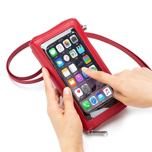 Red leather touchscreen crossbody phone bag with clear window shown in hand use