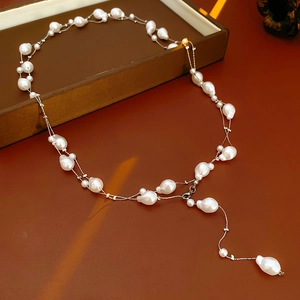Gros plan détaillé d'un collier de perles baroques avec d'élégantes couches de métal argenté