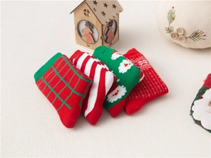 Flat lay of four pairs of kids' Christmas cotton socks with Santa and plaid patterns