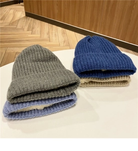 Dettaglio di quattro berretti in maglia grigio, blu e beige con fodera in pile per l'inverno