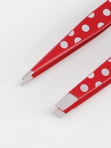 Macro detail of red polka dot stainless steel tweezers with slanted and pointed tips