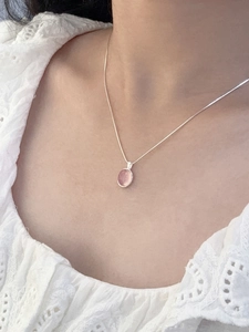 Nahaufnahme einer S925 Silberkette mit rosa Chalzedon-Anhänger am Hals eines Modells