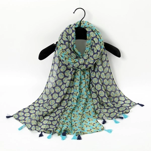 Detailed view of the blue and green geometric pattern scarf with stylish fringe tassels