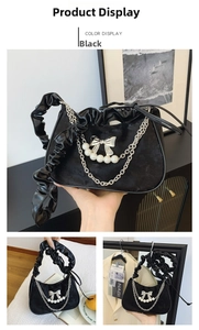 Close-up of black velvet crescent bag with silver bow, pearls, and ruffled handle