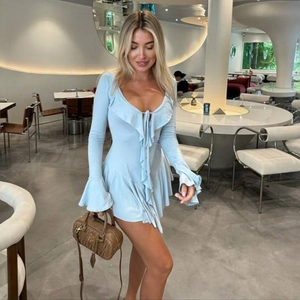 Detail of light blue mini dress featuring deep V-neck, lace-up front and ruffled edges