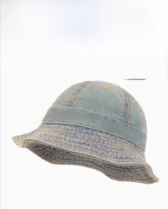 Détail d'un bob en jean bleu clair avec des surpiqûres orange contrastées et coutures