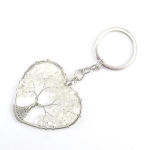 Detail of handmade heart-shaped tree of life keychain with white crystal stones