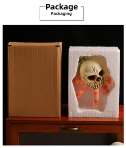 Detailed view of Halloween skull claw resin ornament in protective foam and cardboard box
