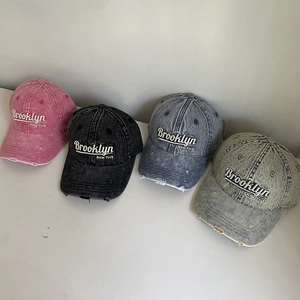 Top view of four washed denim baseball caps with Brooklyn 3D embroidery and distressed holes