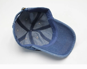 Detailed interior view of a dark blue denim baseball cap with stitching and metal buckle