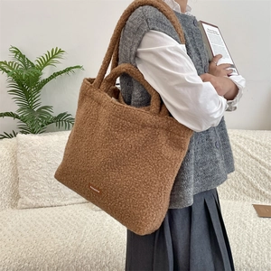 Dettaglio borsa tote in pile orsetto marrone con trama morbida ed etichetta del marchio