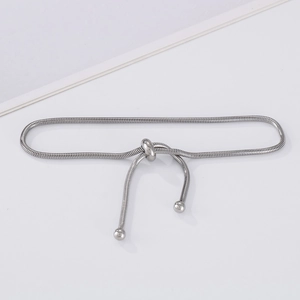 Detail of adjustable silver snake chain bracelet featuring a sliding bead clasp closure