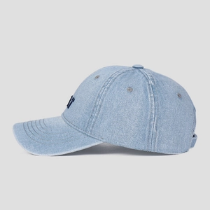 Close-up of light blue denim baseball cap with navy blue embroidery and parallel stitching