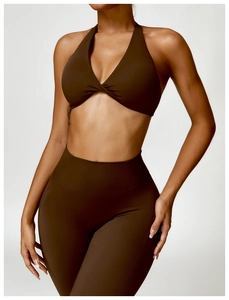 Détail de la brassière de sport marron foncé à licou croisé et du legging taille haute