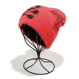 Close-up of bright red plush knit beanie showing soft faux mink fur texture and web pattern