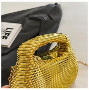 Detailed view of luxury gold metallic swirl evening bag with elegant chain and handle