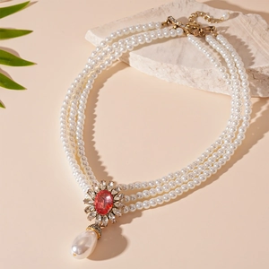 Detail of vintage Baroque triple-layer pearl necklace with red crystal floral pendant