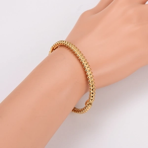 Minimalist gold-tone rivet stud bangle featuring a sleek cone-shaped industrial design