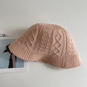 Detail of pink knit bucket hat showing chunky cable pattern and breathable cotton texture