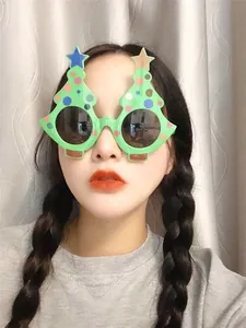 Close-up of festive green Christmas tree party glasses with colorful ornaments and stars