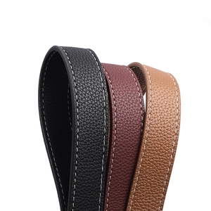 Detail of wide PU leather shoulder straps with litchi texture and white contrast stitching