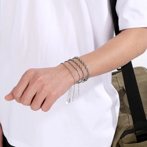 Detail of silver twisted chain bracelets in stainless steel worn on a model's wrist