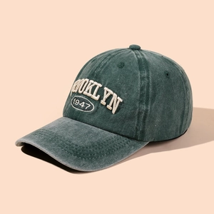 Vintage washed dark green baseball cap with Brooklyn 1947 embroidery in a 45-degree angle view