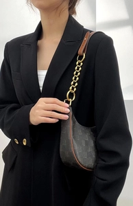 Detail of vintage pattern hobo bag with brown leather strap and golden chain link
