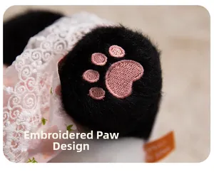 Close-up of pink paw embroidery on black plush panda feet with lace dress detail
