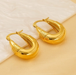 Macro shot of 18K gold plated U-shaped earrings with intricate fish scale textures