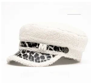 Detail of off-white faux fur cadet hat featuring leopard print brim and metallic M emblem