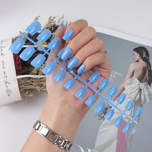 Set of 24 long square light blue glossy press-on nails displayed on a plastic frame