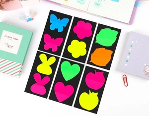 Detailed close-up of colorful butterfly and heart shaped PET index tabs on white surface