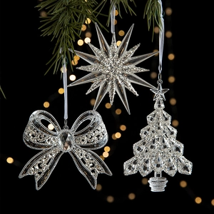 Clear acrylic Christmas ornaments featuring star and crystal tree shapes on pine branches
