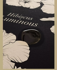 Close-up of black leather texture bath mat with beige floral pattern and liquid drop