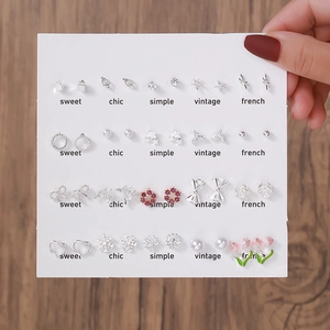 Vue détaillée de 20 paires de boucles d'oreilles élégantes avec perles et nœuds sur carte