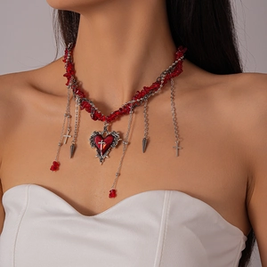 Detail of Gothic Y2K necklace featuring red gravel beads, silver chains, and heart cross charm