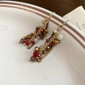 Detailed shot of vintage beaded tassel earrings with crystal chains and golden hooks