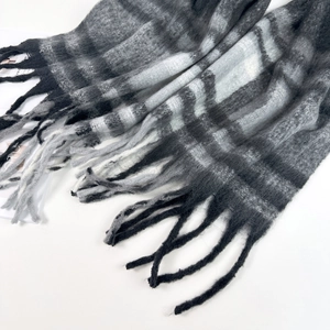 Close-up of black and white plaid mohair scarf texture with long fringe tassels