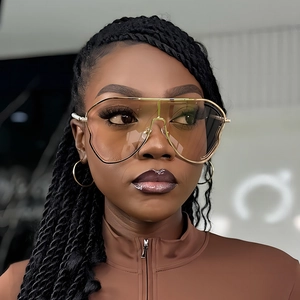 Lunettes de soleil oversize monture dorée et verres dégradés marron portées par mannequin