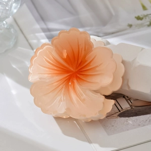 Macro shot of pink gradient flower hair claw clip with glossy resin texture and petal details