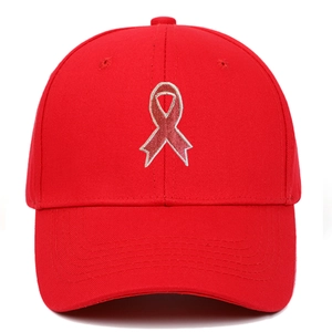 Close-up of a red cotton baseball cap featuring a detailed red ribbon embroidery design