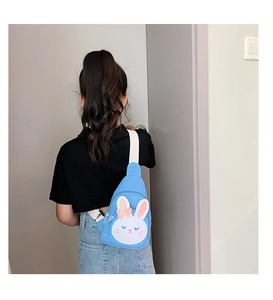 Rear view of a child wearing a cute blue rabbit canvas crossbody bag with glitter ears