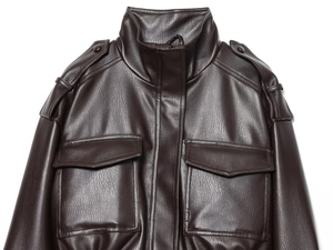 Detail of dark brown faux leather jacket featuring standing collar and shoulder epaulettes