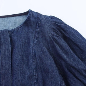 Detail eines dunkelblauen Jeanskleids mit Rundhalsausschnitt und Puffärmel-Konstruktion