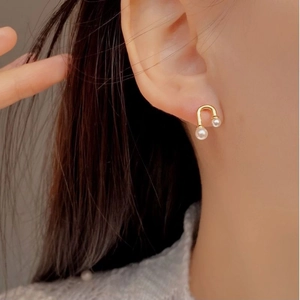 U-shaped 925 silver pearl stud earrings in gold finish with delicate musical note design