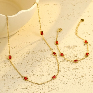 Elegant gold-plated jewelry set with square red zircon necklace and bracelet on neutral background