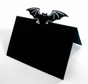 Folded black paper place card featuring a laser-cut bat design for Halloween table decor