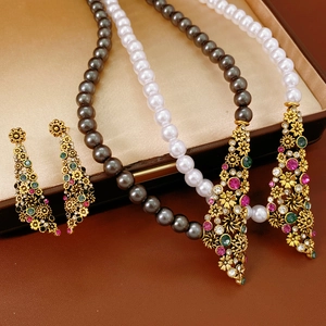 Détail d'un ensemble collier de perles et boucles d'oreilles vintage avec pierres gemmes